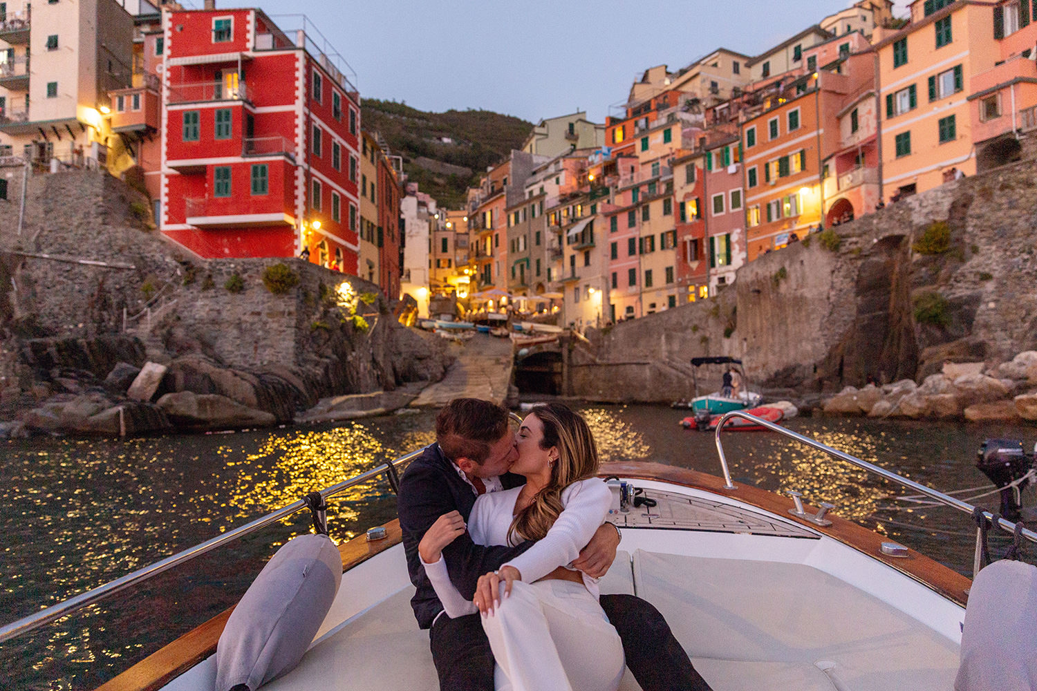 Couple kissing on a boat in Cinque Terre at night