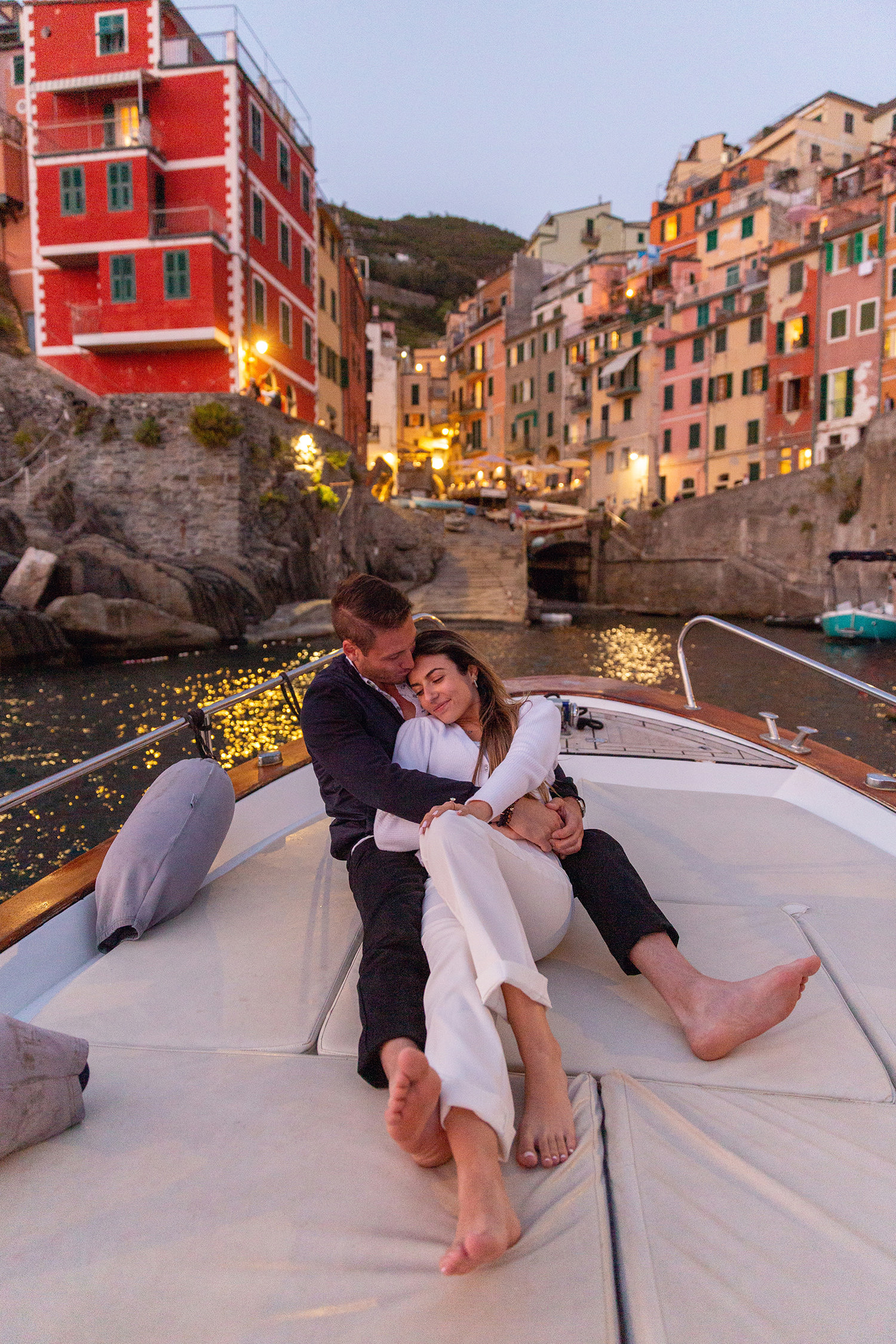 Couple hugging on a boat after he proposed in Riomaggiore, Cinque Terre, captured by Cinque Terre Photographers