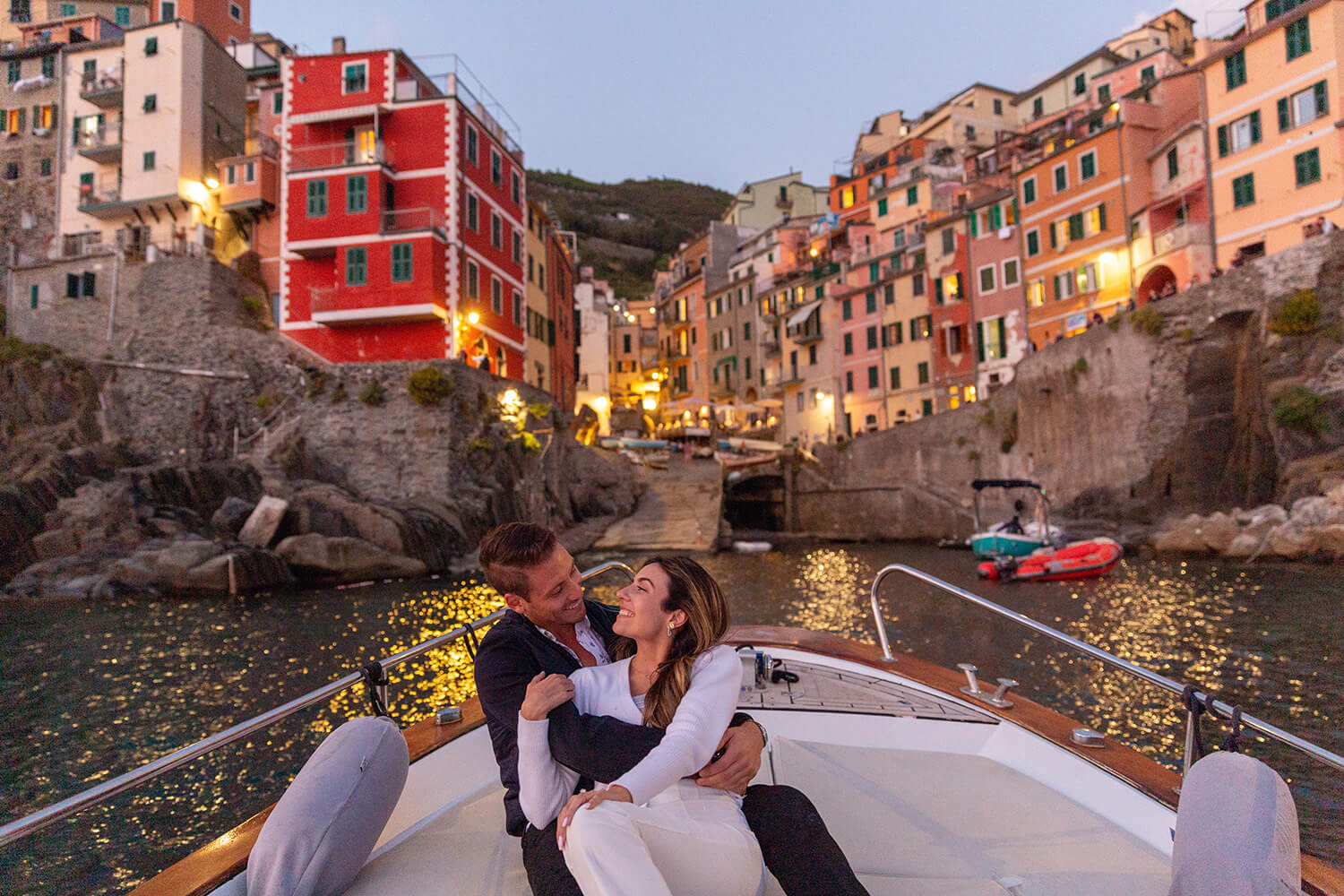 Couple on a boat in front of Riomaggiore after a surprise proposal