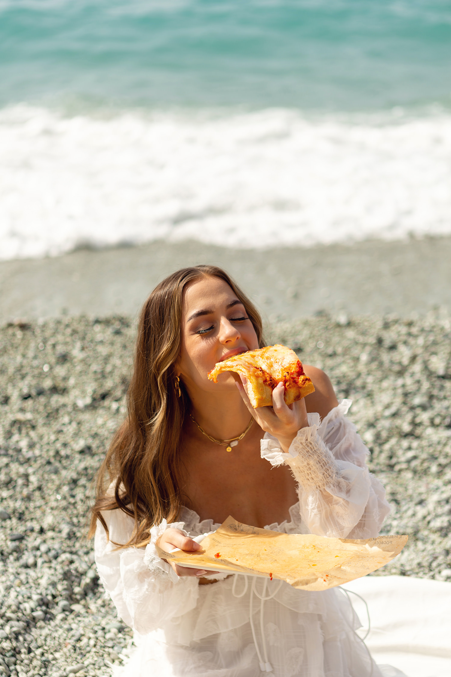Girl eating a slice of pizza in Cinque Terre, La Spezia