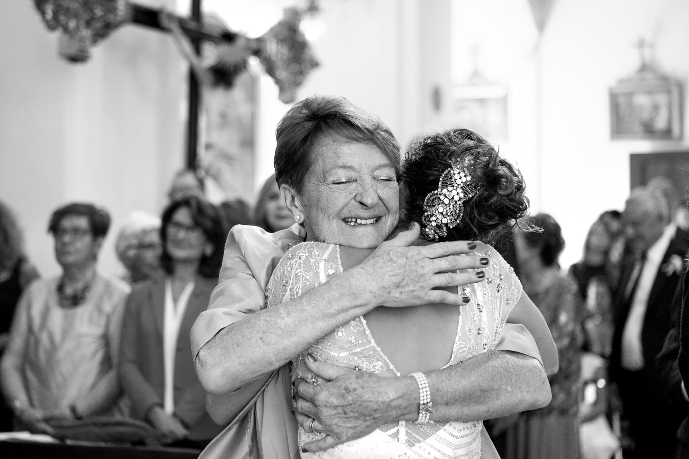 Mom of the husband hugging the bride after the ceremony at their wedding