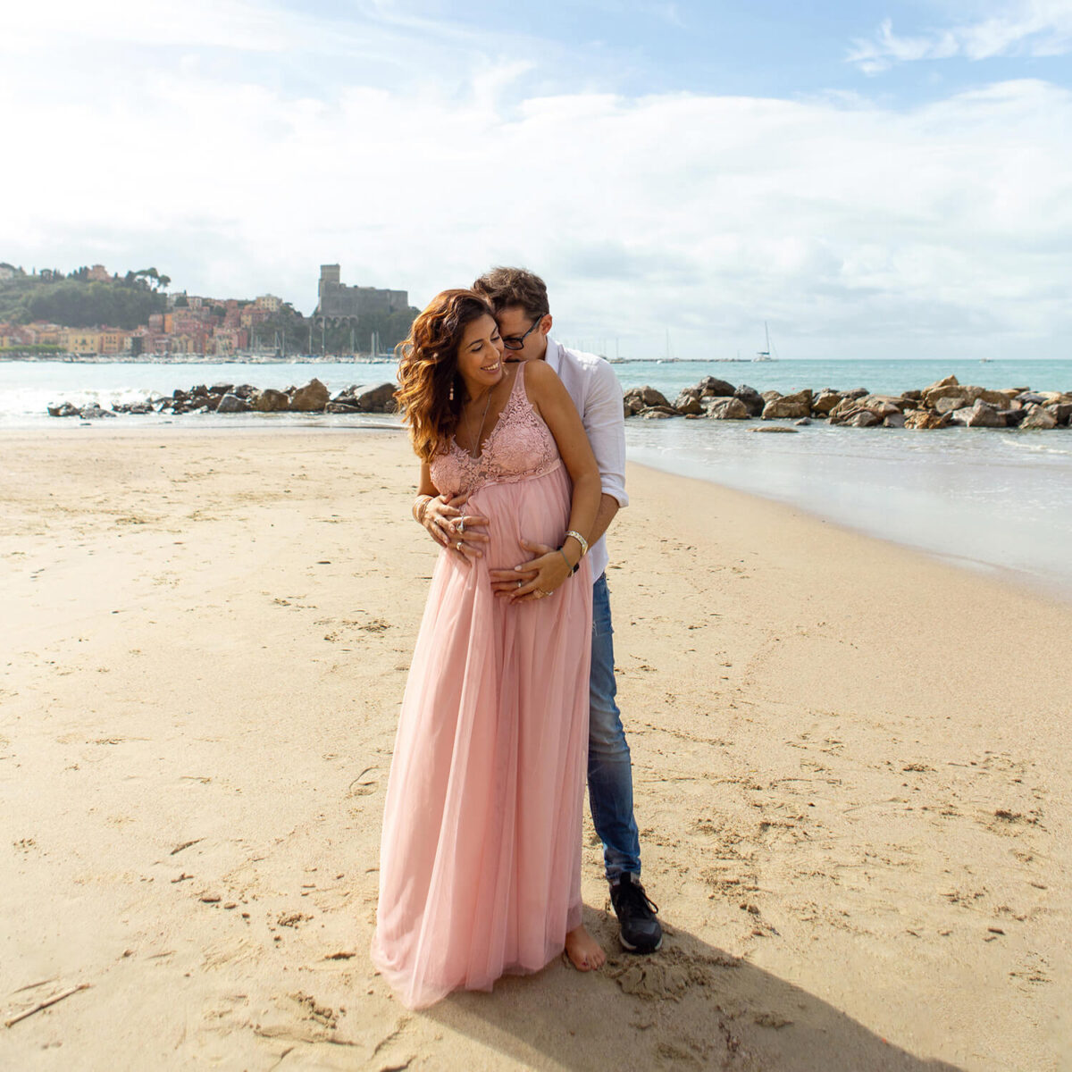 Coppia che si abbraccia durante un servizio fotografico di gravidanza al mare a Lerici
