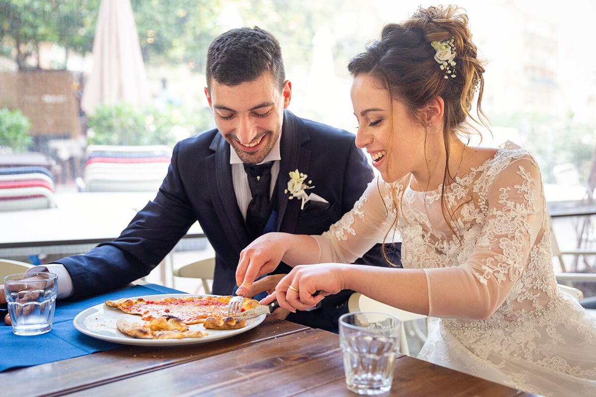 Bride and groom eating pizza after their Wedding in Cinque Terre, Italy