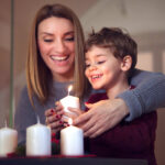Mamma che accende la candela dell'Avvento durante un servizio fotografico di Natale in casa a La Spezia