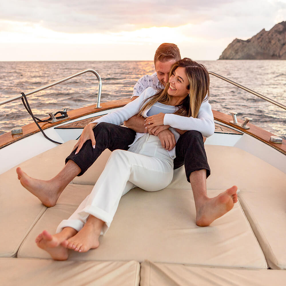 Couple enjoying a private boat tour along Cinque Terre to celebrate their engagement after a surprise proposal