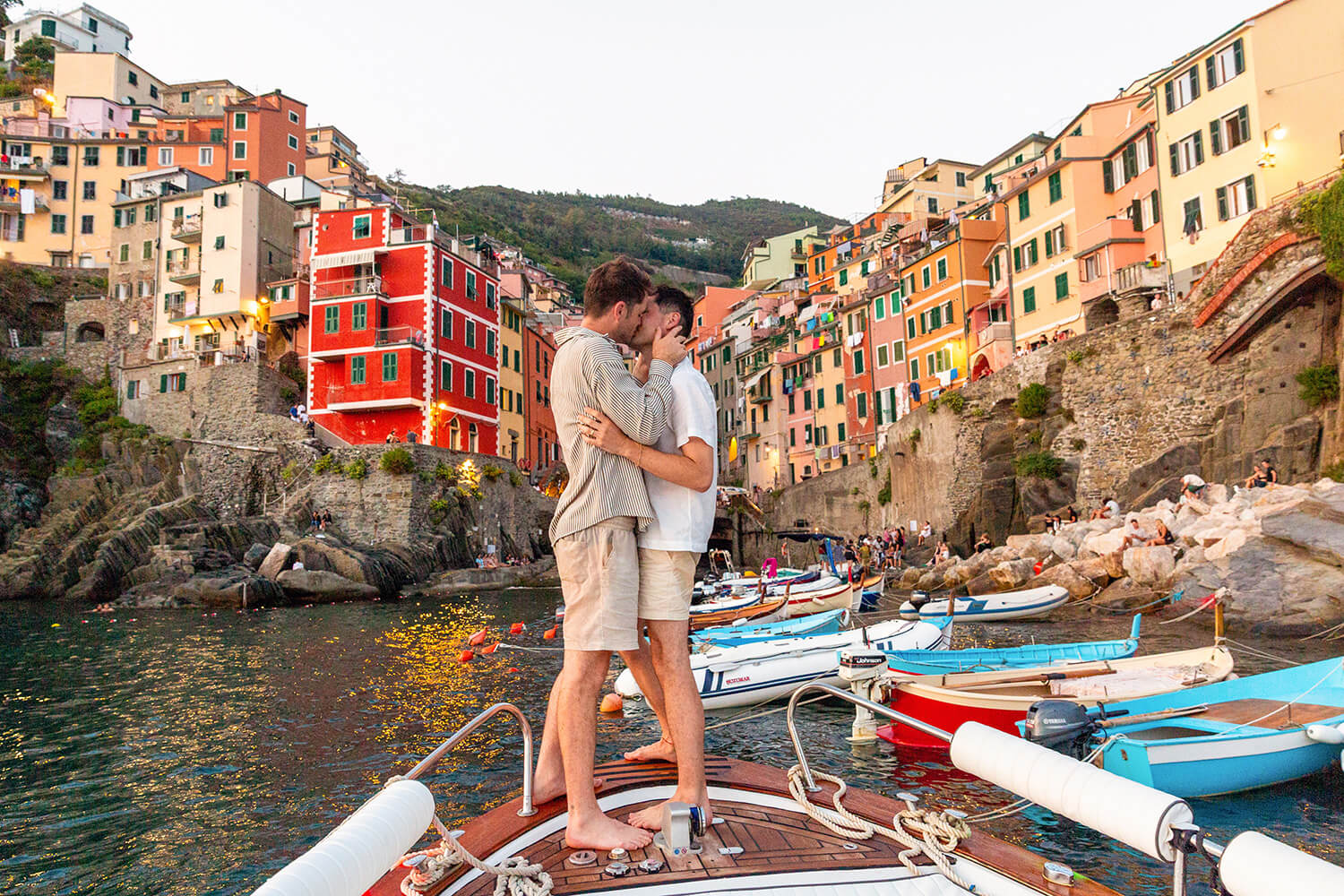 Couple kissing on a boat at sunset in front of Riomaggiore, Cinque Terre
