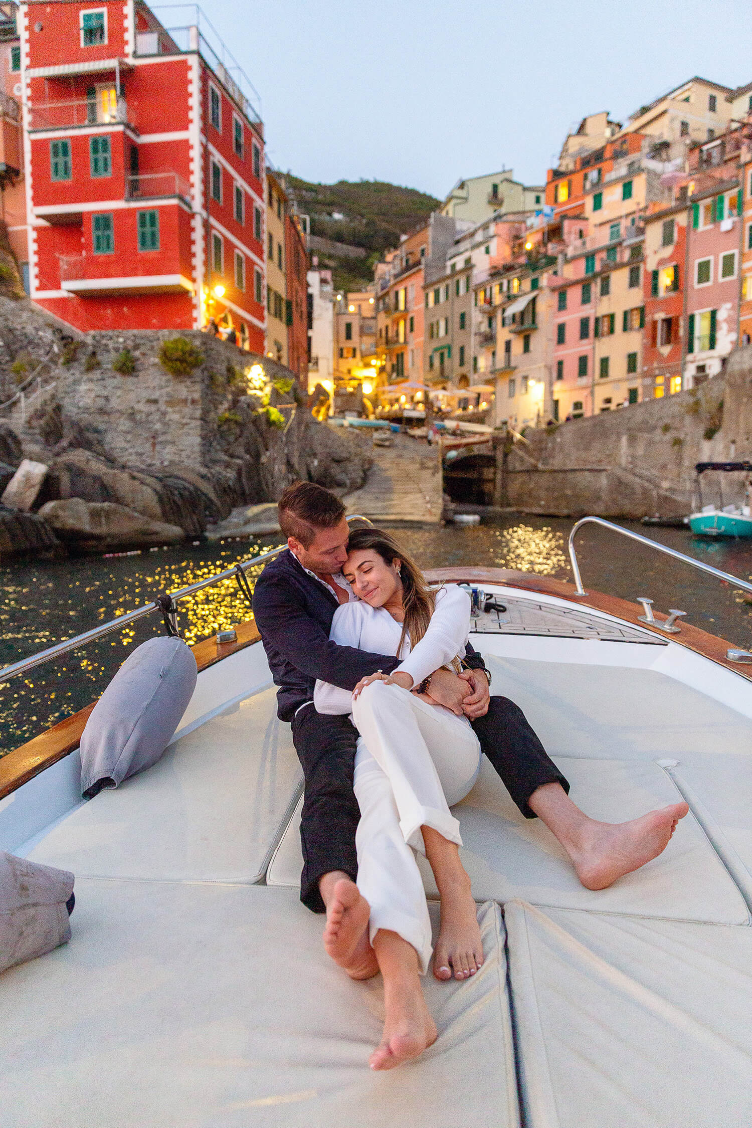 Couple hugging on a boat at sunset in Riomaggiore, Italy - captured by Cinque Terre Engagement photographers