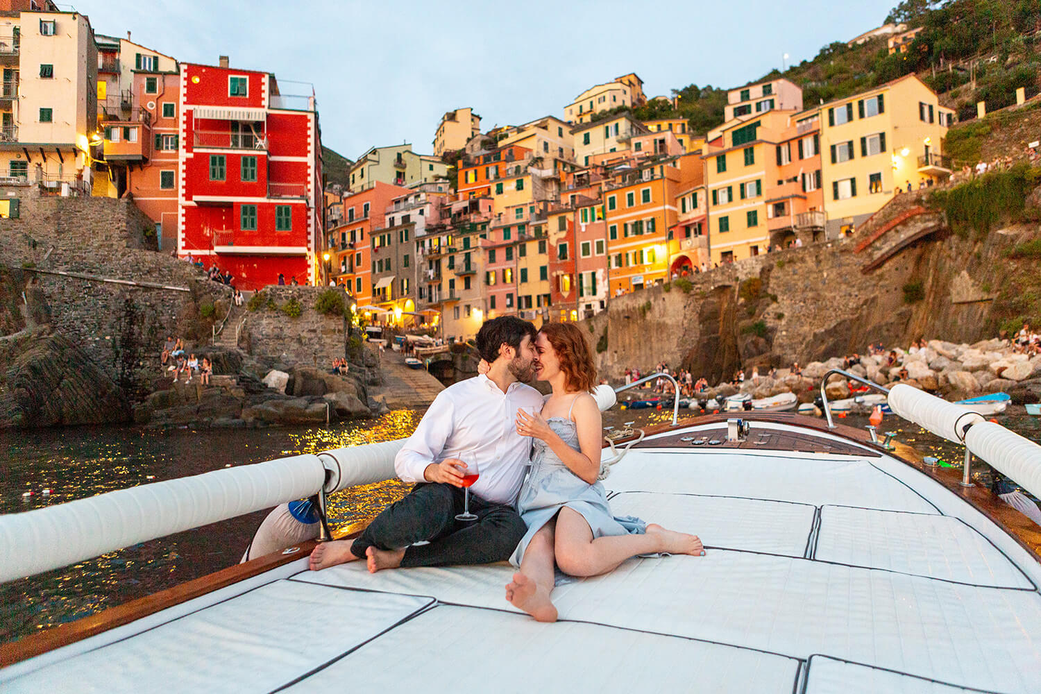 Couple kissing on a boat in Riomaggiore at sunset after a surprise proposal